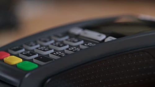 Close up of a person using a bank card for payment at a shop checkout terminal