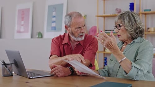 Senior Couple Discussing Documents at Home Together