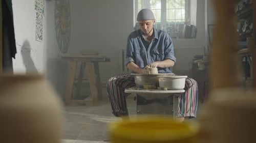 Un maître potier travaille au tour du potier avec de l'argile