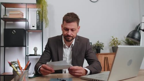 Stressed Businessman Looking at Unpaid Bank Debt Loan Throws Paper Document Bills Financial Crisis