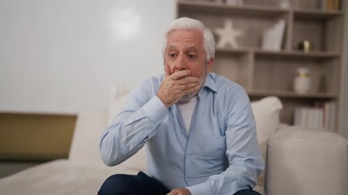 Un homme âgé se sent mal et a une toux terrible, un homme âgé aux cheveux gris souffrant d'asthme