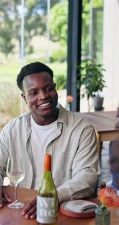 Happy, friends and man in restaurant with wine for social gathering, reunion and tasting event