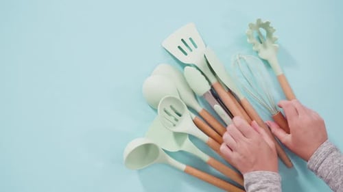 Flat Lay New Blue Silicone Kitchen Utensils with Wooden Handles on a Blue Background