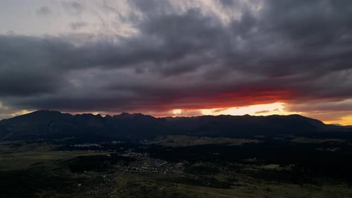 Brillante puesta de sol en las montañas. Nubes épicas rojas. Vista aérea.