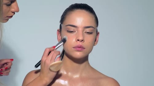 Woman Receives Makeup Application in Studio Setting