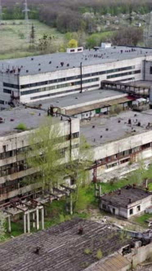 Panoramic view of an old factory. Abandoned territory of industrial plant with large brick pipe
