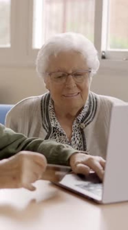 Senior Woman Using Laptop with Another Person