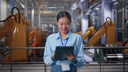 Woman Uses Tablet in Modern Factory with Robots