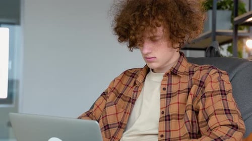 Young Adult Working on a Laptop at Home
