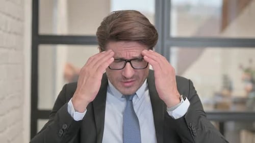 Portrait of Businessman with Headache in Office