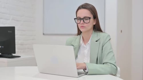 Professional Woman Typing on Laptop and Smiling