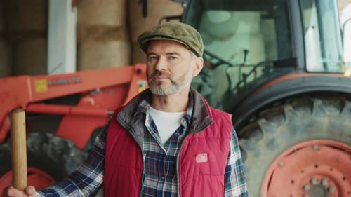 Portrait Handsome Young Farmer in Hat Standing Look at Camera On Background Tractor In Farm Close Up