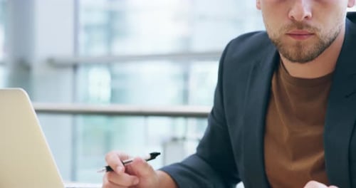 4k video footage of a handsome young businessman using his tablet while working in the office