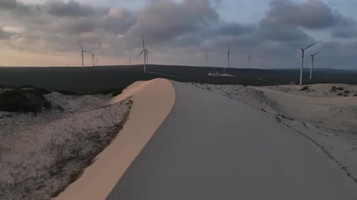 Desert Sand Dune with Wind Turbines at Sunset