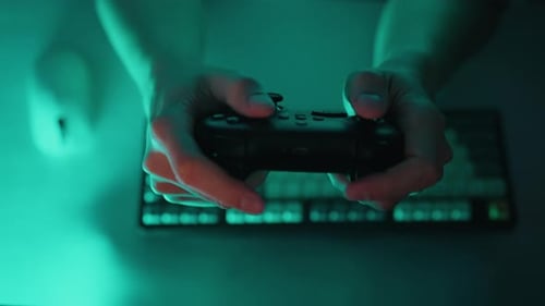 Man Holds Controller to Play Video Games
