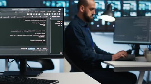 Focused Software Engineer Working in a High-Tech Data Center at Night