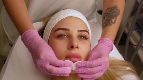 Woman Receiving Gentle Facial Cleansing at Spa