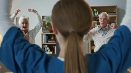 Elderly People Following Caregiver during Group Fitness Session at Nursing Home