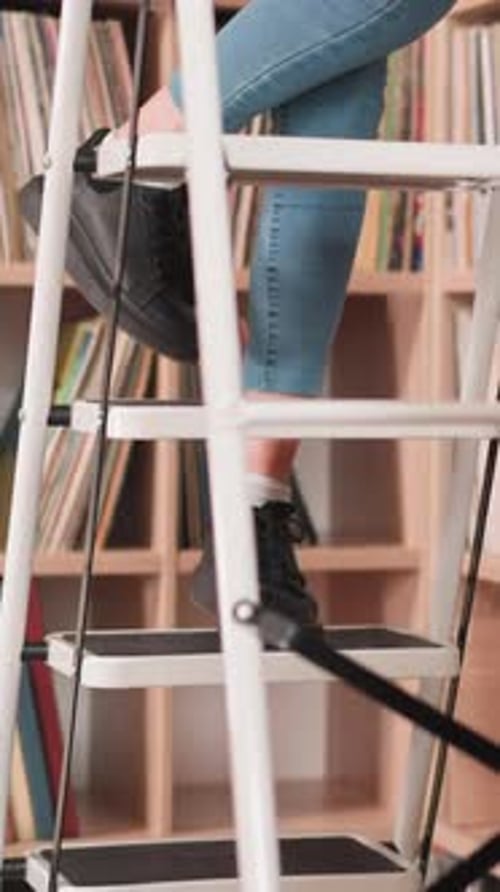 Woman Ascending Stepladder Near Bookcase