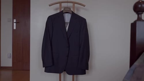 Elegant Dark Suit Jacket Hanging Indoors