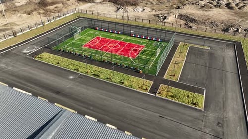 Aerial shot of a contemporary school facility featuring outdoor sports court