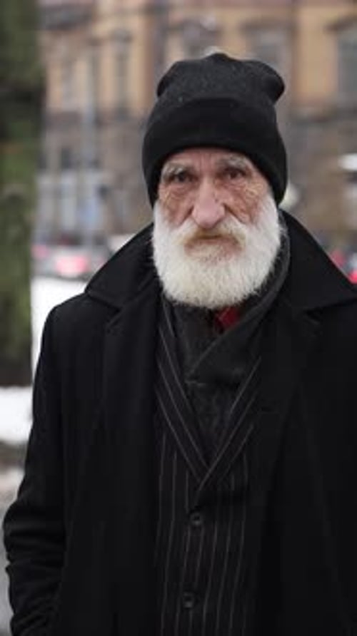 An Elderly Man with a Long White Beard is Waving His Index Finger