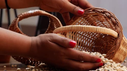 Woman Moves Dried Beans Near Wicker Baskets