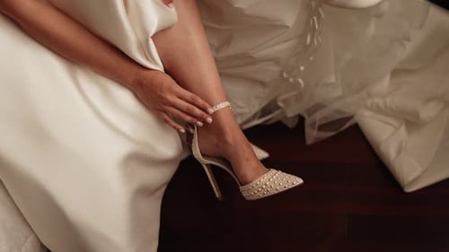 Woman Strapping on Bridal Shoes Before Her Wedding