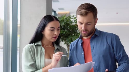 Two Business People Discussing About Work in an Office