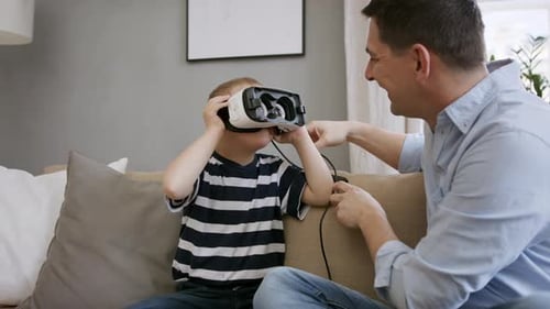 Father and Son Enjoying VR Headset on Couch