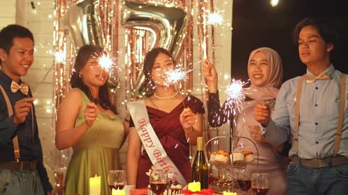 Birthday Celebration with Friends Holding Sparklers at Night