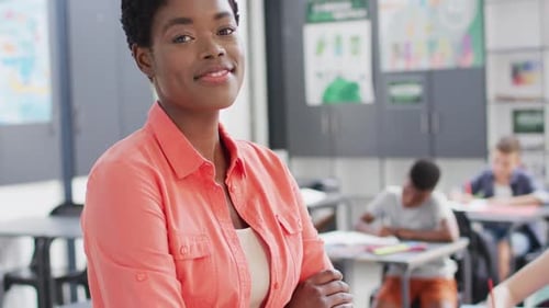 Portrait of diverse female teacher and schoolchildren at desks in school classroom