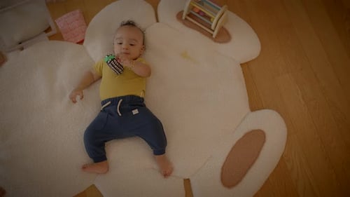 Infant Lying on Rug Holding Toy