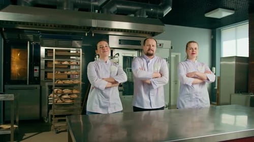 a team of smiling professional bakers in a professional kitchen in a bakery before the start baking