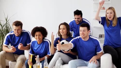 Excited friends cheering while watching sports on TV