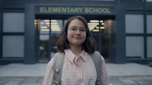 Happy Schoolgirl Portrait at School Entrance