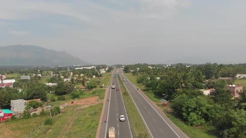 Flying over the centerline of a highway in India with full of traffic