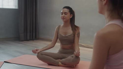 Woman Meditating with Yoga Instructor in Studio