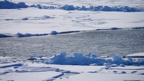 A Serene View of Melting Polar Ice with a Partially Frozen Water Body Surrounded By Thick Snow and