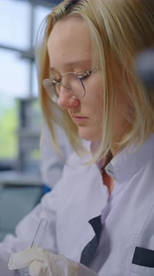 Woman Scientist in Lab Coat Holding Test Tube