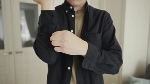 Man Rolls Up Sleeves Indoors