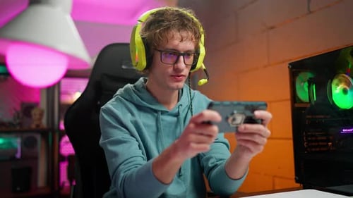 Young Adult Playing Game on Smartphone at Home