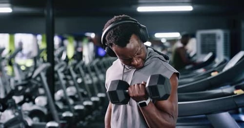 Man, headphones and dumbbell at gym for fitness, streaming podcast and weightlifting