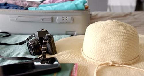 Travel Essentials and Packed Suitcase on a Bed