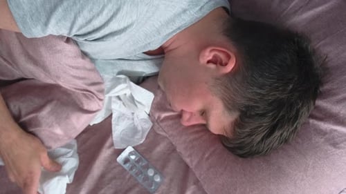 Man Sick in Bed with Cold and Flu