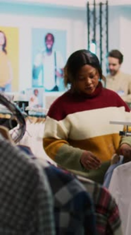 Vertical Video Store Customer Taking Shirt Off of Hangers to Buy Clothes