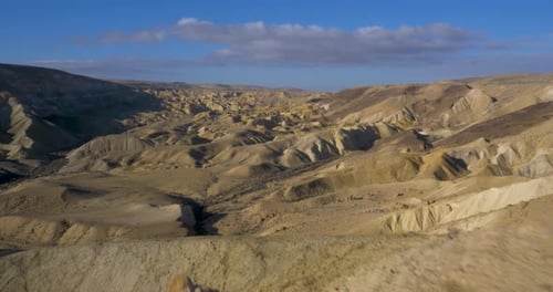 Drone flys over desert mountain top to reveal massive rugged dry valley