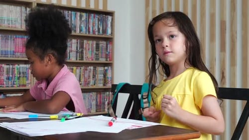 Young Girls Drawing Together at School Table