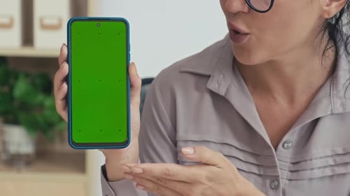 Woman Presenting Application on Smartphone with Green Chroma Key Screen