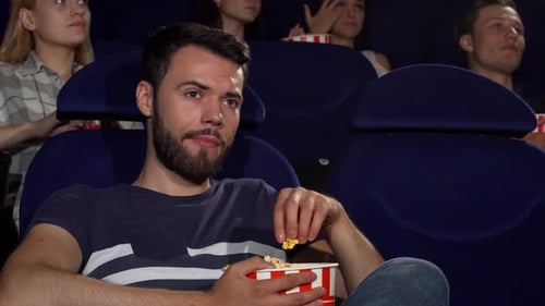 Young Adults Watching Movie and Eating Popcorn